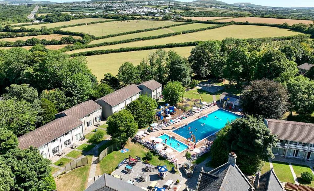 Aerial view of holiday cottages and the outdoor pool at Atlantic Reach in Cornwall